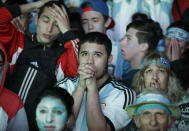 Argentina soccer fans watch in disbelief the final World Cup match between Argentina and Germany on an outdoor television screen set up in Buenos Aires, Argentina, Sunday, July 13, 2014. Mario Goetze volleyed in the winning goal in extra time to give Germany its fourth World Cup title with a 1-0 victory over Argentina. (AP Photo/Jorge Saenz)