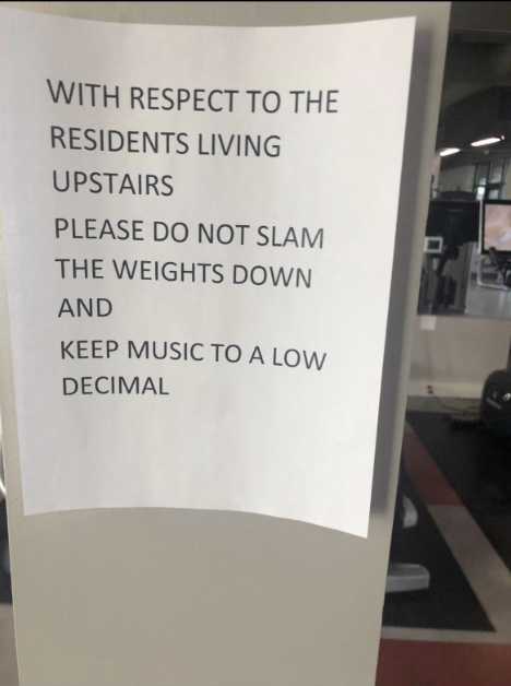 Gym sign asks to respect upstairs residents by not slamming weights and keeping music "to a low decimal"