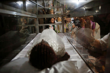 People gather around religious statues and objects after a service in a chapel at Camp Crame, the headquarters of Philippine National Police (PNP) in Manila, Philippines October 9, 2016. REUTERS/Damir Sagolj