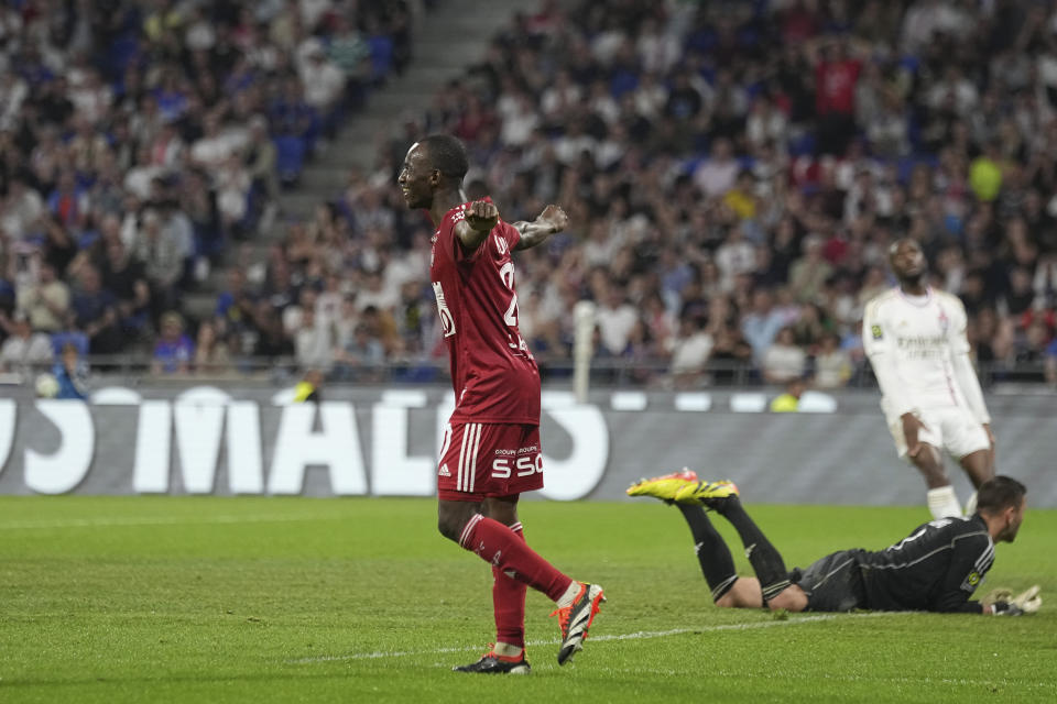 Brest's Kamory Doumbia, center, celebrates after his teammate Romain Del Castillo scoring their side's third goal during a French League One soccer match between Lyon and Brest at the Groupama stadium, outside Lyon, France, Sunday, April 14, 2024. (AP Photo/Laurent Cipriani)
