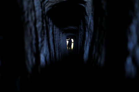 A figure is seen inside one of two manmade tunnels excavated by Hebrew University archaeologist Oren Gutfeld in the Judean desert near the Qumran area, during a tour for Reuters journalists at the site, in the Israeli-occupied West Bank October 14, 2018. REUTERS/Ronen Zvulun