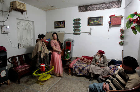 Bubbly helps Shakeela with her dress as members of the transgender community prepare for Shakeela's party in Peshawar, Pakistan January 22, 2017. REUTERS/Caren Firouz