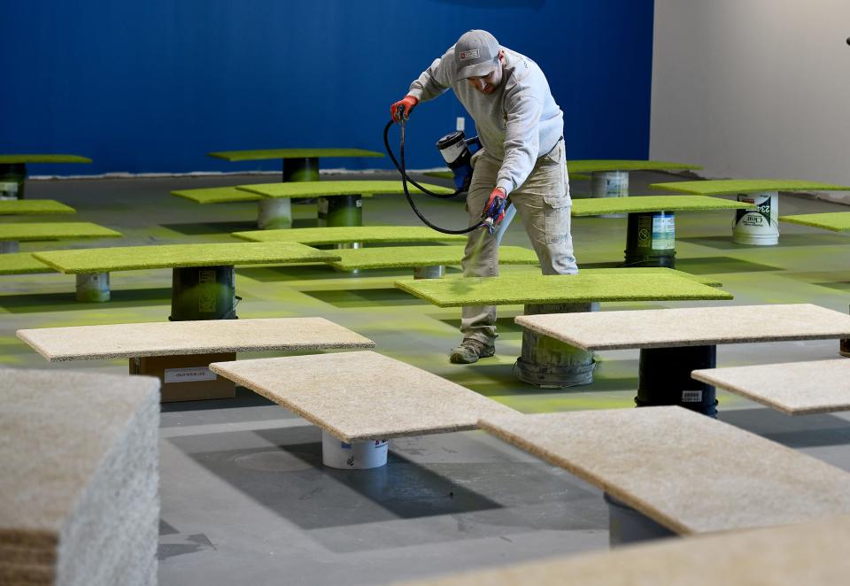 At Pickleball U in Sturbridge, a subcontractor paints sound deadening panels, which will go on the walls.