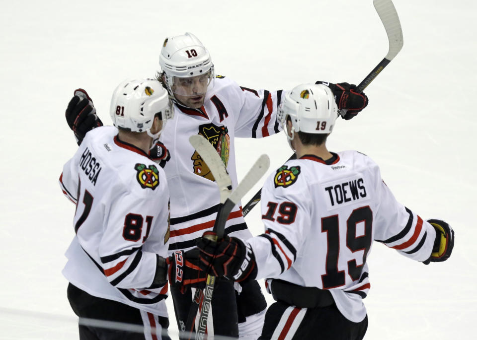 Chicago Blackhawks left winger Patrick Sharp (10) and right winger Marian Hossa (81), of the Czech Republic, celebrate a goal by center Jonathan Toews (19) against the Anaheim Ducks in the third period of an NHL hockey game in Anaheim, Calif., Wednesday, Feb. 5, 2014. The Blackhawks won, 2-0. (AP Photo/Reed Saxon)