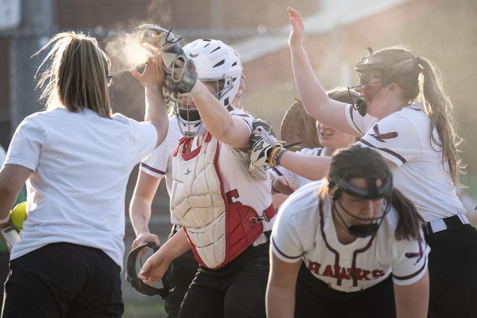 Hudson softball coach Laura Bowen high fives Lauren O'Malley after making she made an out to end the second inning of Monday's win over Clinton.