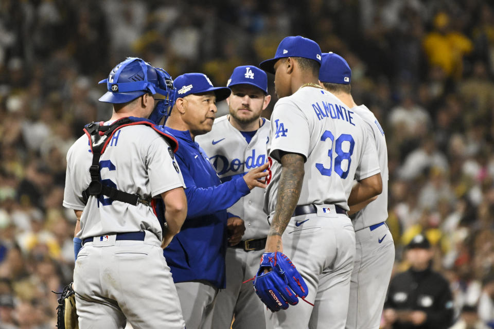 San Diego, CA - 15 de octubre: El gerente de los Dodgers de Los Ángeles, Dave Roberts, segundo desde la izquierda, habla con el lanzador de relevo Yency Almonte durante la séptima entrada del juego 4 de la SDLN contra los Padres de San Diego en Petco Park el sábado 15 de octubre. 2022 en San Diego, CA.  (Wally Skalij / Los Ángeles Times a través de Getty Images)