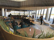 Virgin Galactic employees gather in the ground floor lounge at Spaceport America near Upham, New Mexico, on Thursday, Aug. 15, 2019. Virgin Galactic unveiled some of the interior spaces of the custom-tailored terminal Thursday, saying the designs are aimed at connecting the customers with operations as they prepare for their suborbital flights. (AP Photos/Susan Montoya Bryan)