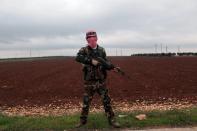 A member of the Syrian opposition Al-Buraq Brigade stands on December 10, 2012 on a main road in the town of Ain Dakna. "The participants acknowledged the National Coalition as the legitimate representative of the Syrian people and the umbrella organisation under which Syrian opposition groups are gathering," said the statement to be approved by a meeting of the Friends of Syria group in Morocco