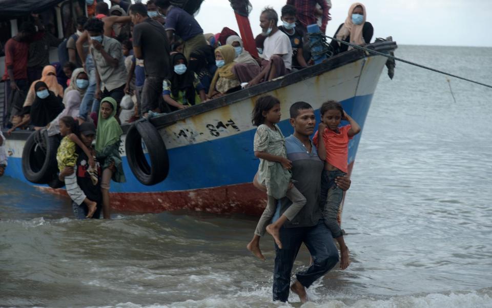 Residents conduct a forced evacuation of Rohingya from ships on the coast of Lancok - Rahmat Mirza/Opn Images/Barcroft Media via Getty Images