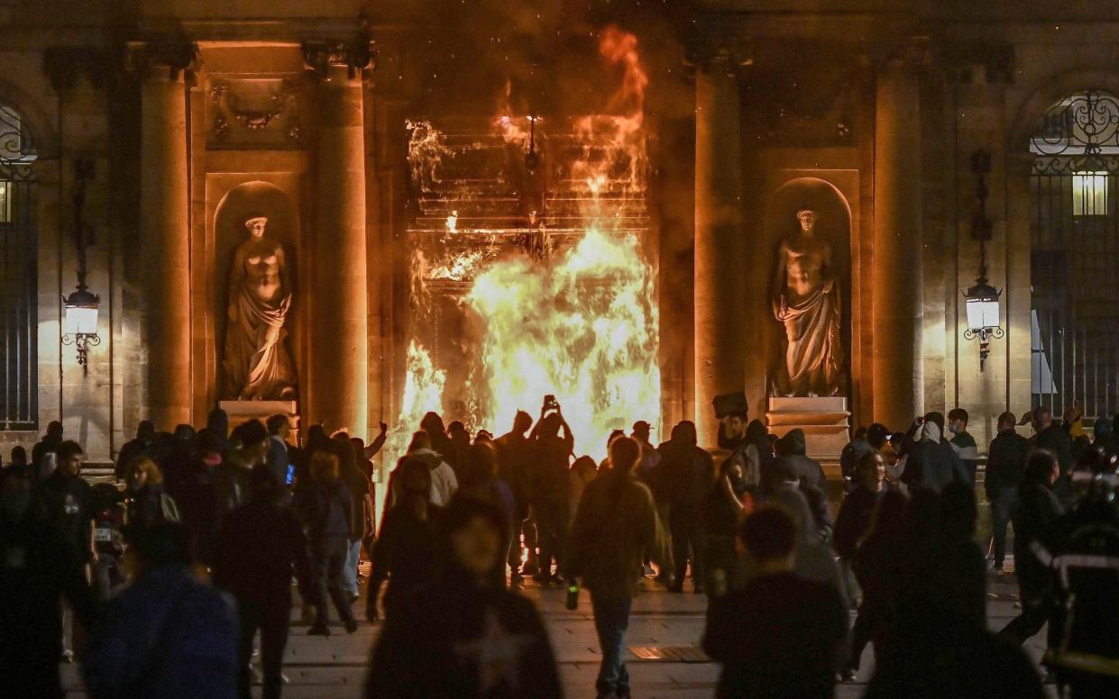 The entrance to the city hall in Bordeaux burns during protests in France. Violent clashes have forced Emmanuel Macron to cancel the King's state visit - Ugo Amez/Sipa/Shutterstock