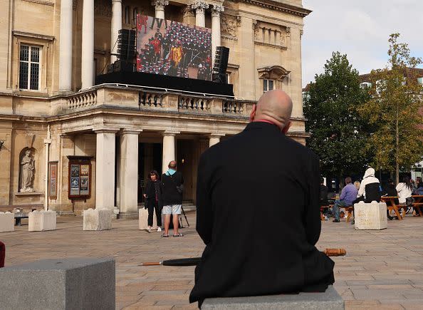 HULL, ENGLAND - SEPTEMBER 19:  Members of the public react as the funeral of Her Majesty Queen Elizabeth II is screened at Hull City Hall on September 19, 2022 in Hull, United Kingdom. Elizabeth Alexandra Mary Windsor was born in Bruton Street, Mayfair, London on 21 April 1926. She married Prince Philip in 1947 and acceded to the throne of the United Kingdom and Commonwealth on 6 February 1952 after the death of her Father, King George VI. Queen Elizabeth II died at Balmoral Castle in Scotland on September 8, 2022, and is succeeded by her eldest son, King Charles III. (Photo by Nigel Roddis/Getty Images)