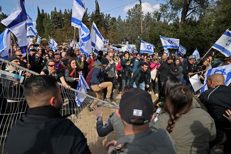 Manifestantes israelíes empujan una valla frente al Knesset (parlamento) en Jerusalén el 13 de febrero de 2023, durante una manifestación contra las controvertidas reformas legales que promociona el gobierno de extrema derecha del país. (Foto de AHMAD GHARABLI / AFP)