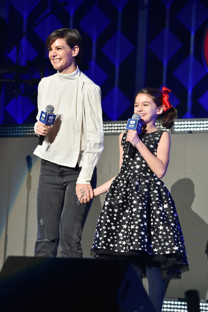 Katie Holmes holding hands with her daughter onstage