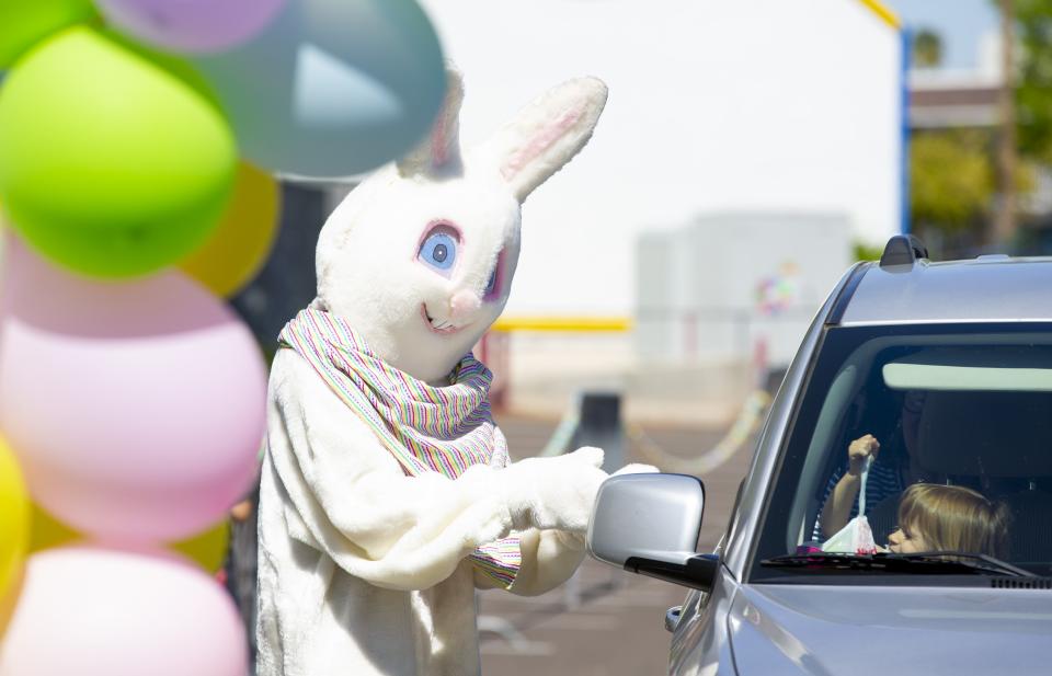 The Easter bunny at Mesa Golfland-Sunsplash greets Jacey Rall, 2, of Scottsdale,during a Easter giveaway drive up on April 10, 2020.  For $5 guests received a one $5 arcade card for future use and 10 pre-packaged Easter eggs.
