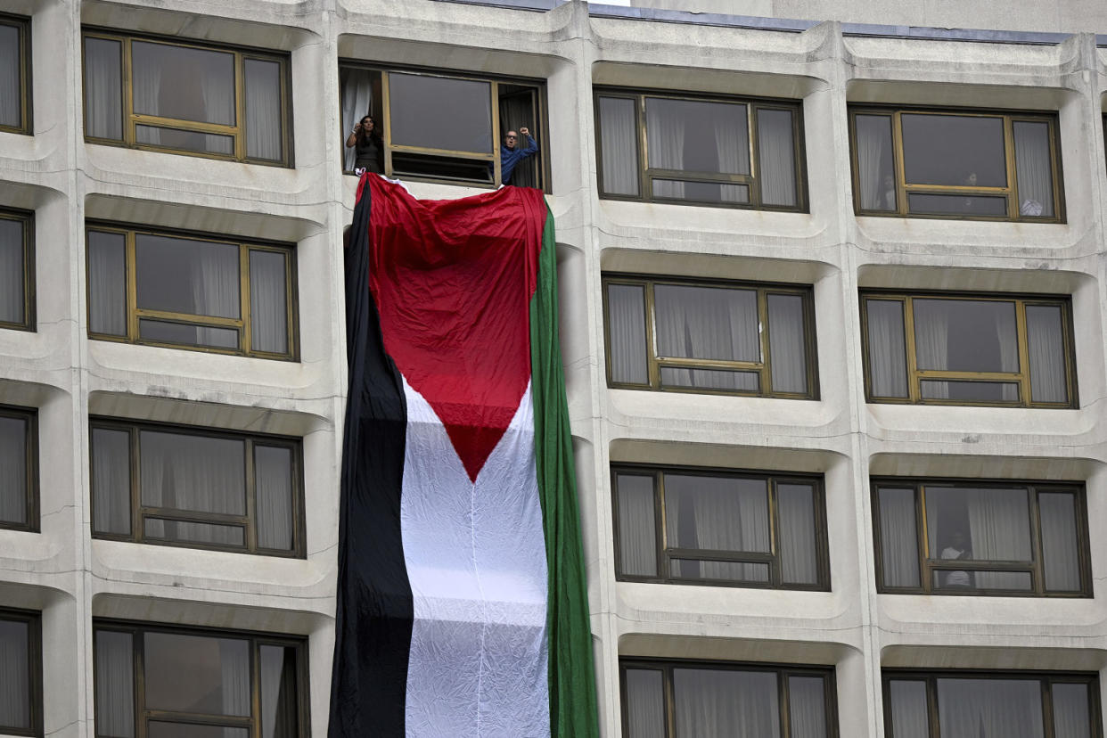 A Palestinian flag hands out a window at the Washington Hilton hotel during a protest over the Israel-Hamas war, at the White House Correspondents' Association dinner on Saturday. (Terrance Williams / AP)