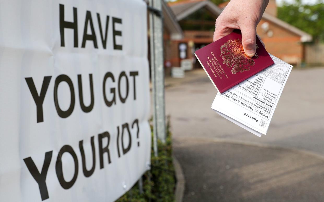 A voter carrying his passport along with his local elections polling card, arriving at a polling station as voters in England need an accepted form of photographic identification to vote in person for May's local council elections. PA Photo. Issue date: Thursday April 20, 2023