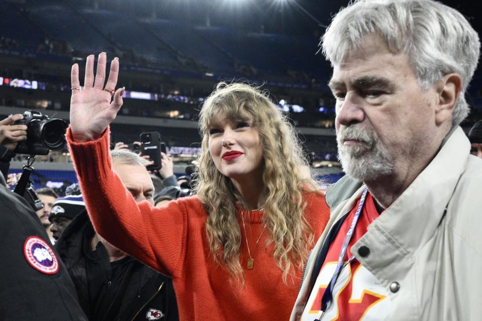 Taylor Swift saluda mientras camina con Ed Kelce después del partido de fútbol americano de la Liga Americana entre los Baltimore Ravens y los Kansas City Chiefs, el domingo 28 de enero de 2024, en Baltimore. Los Chiefs ganaron 17-10. (AP Foto/Nick Wass)