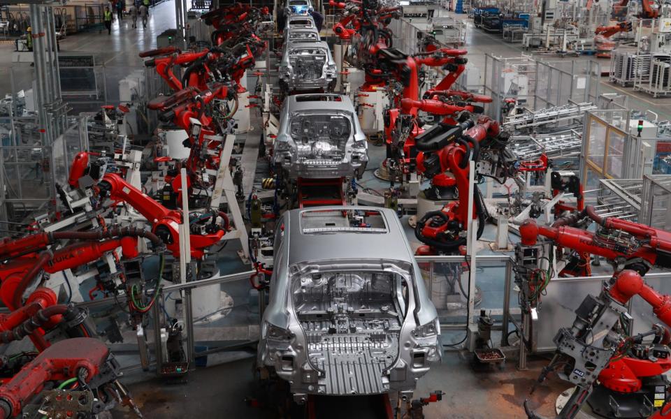 Robotic arms work on the assembly line of T03 electric small crossover at a factory of Chinese EV startup Leapmotor on July 20, 2022 in Jinhua