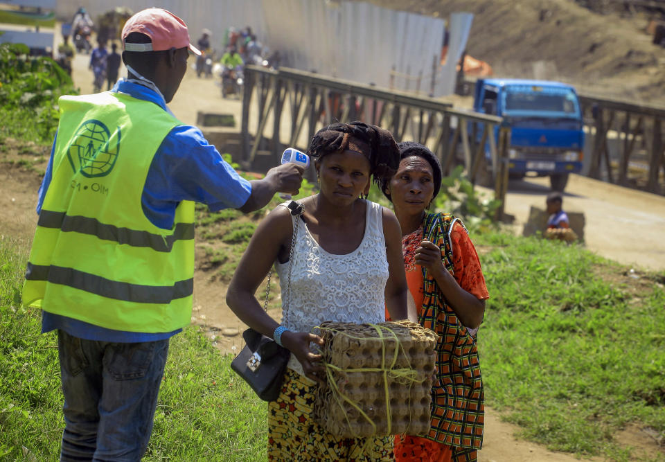 People crossing the border have their temperature taken to check for symptoms of Ebola, at the border crossing near Kasindi, eastern Congo Wednesday, June 12, 2019, just across from the Ugandan town of Bwera. In Uganda, a 5-year-old boy vomiting blood became the first cross-border victim of Ebola in the current outbreak on Wednesday, while two more people in Uganda tested positive for the highly contagious disease that has killed nearly 1,400 in Congo. (AP Photo/Al-hadji Kudra Maliro)