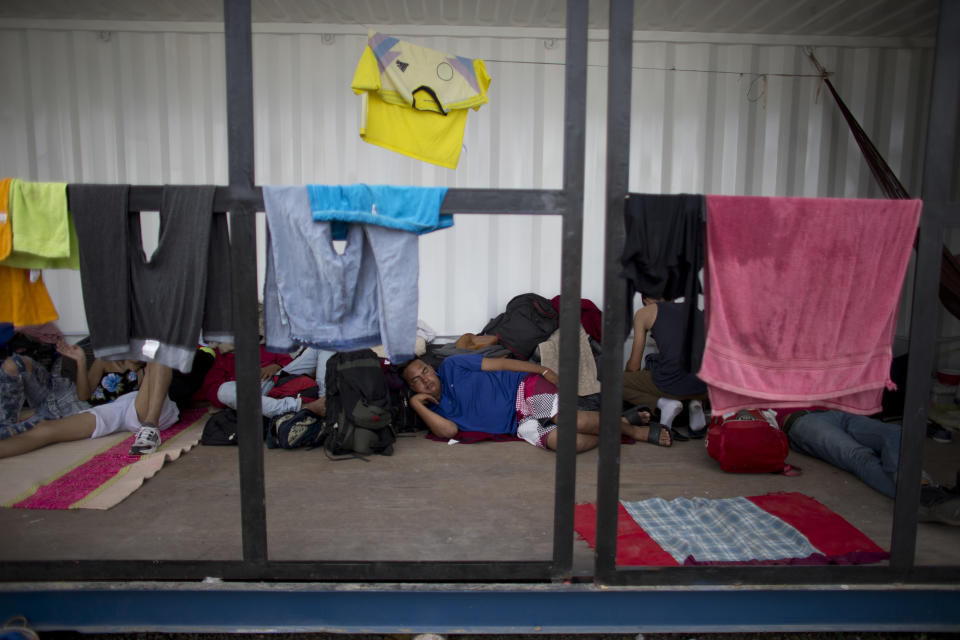 In this Sept. 7, 2018 photo, Venezuelans rest as they wait in a shipping container near Peru's immigration office in Aguas Verdes, Peru. Venezuelan migrants who can't afford a bus or plane flee by foot, risking their lives as they try to cross through four countries and over two thousand miles of often unforgiving terrain ripe with danger to reach Peru. (AP Photo/Ariana Cubillos)