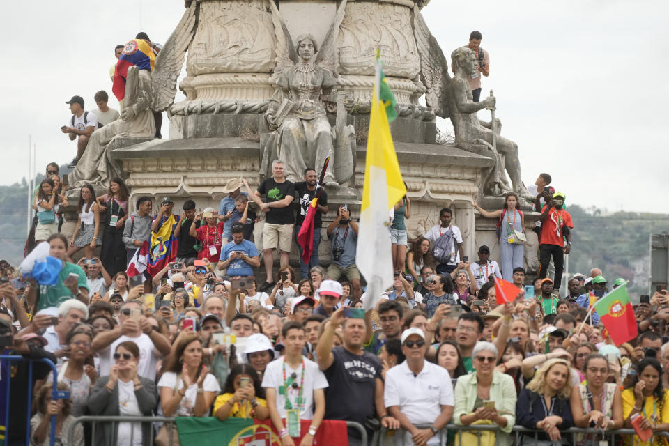 People wait for the arrival of Pope Francis at the Palacio Nacional de Belem presidential palace in Lisbon, Wednesday, Aug. 2, 2023. Pope Francis arrived Wednesday in Lisbon to attend the international World Youth Day on Sunday that is expected to bring hundreds of thousands of young Catholic faithful to Portugal. (AP Photo/Gregorio Borgia)