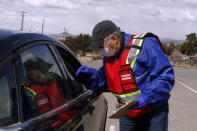 A health workers check paperwork ahead of a Moderna COVID-19 vaccine drive outside of the County Fairgrounds on Friday, April 23, 2021, in Santa Fe, N.M. (AP Photo/Cedar Attanasio)