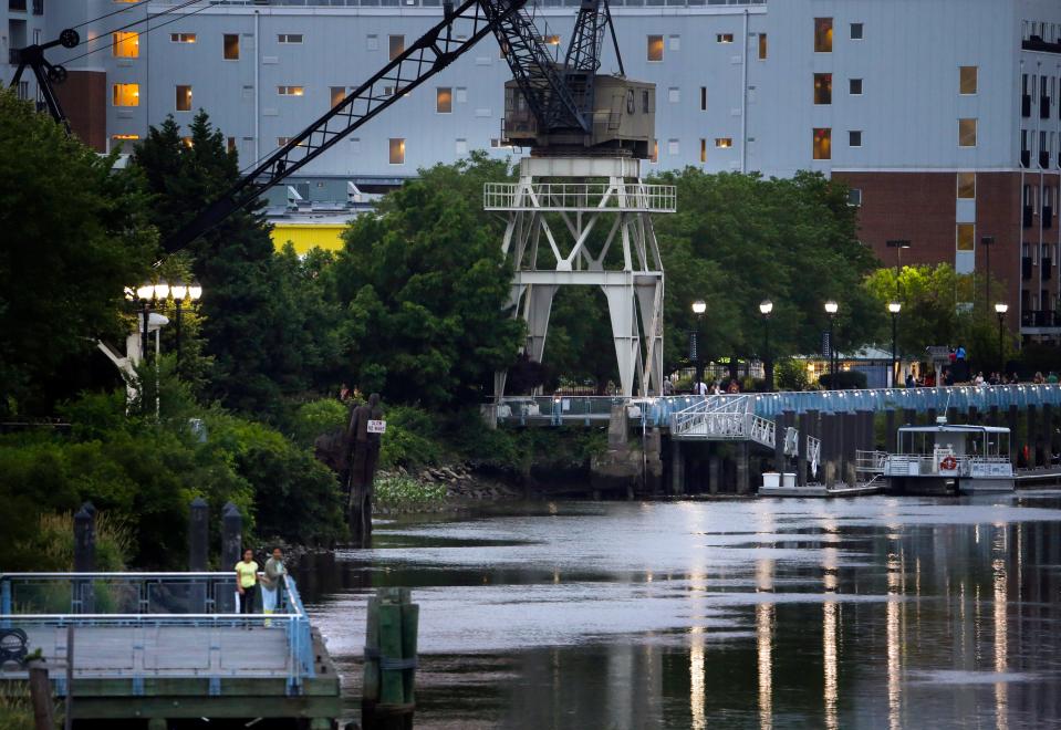 People stroll along the Wilmington Riverfront on a calm summer-like night.