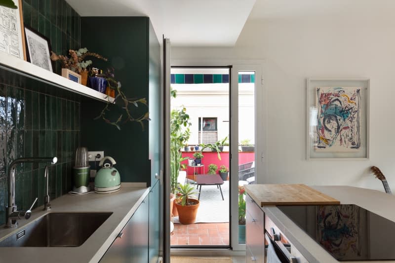 The view from a kitchen out to an outdoor space with plants and a sitting area.