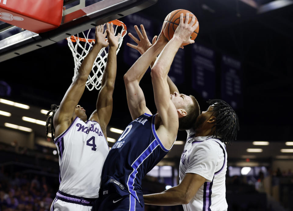 BYU forward Noah Waterman (0) attempts to score as Kansas State guard Dai Dai Ames (4) and forward Will McNair Jr., right, defend during the first half of an NCAA college basketball game, Saturday, Feb. 24, 2024, in Manhattan, Kan. (AP Photo/Colin E. Braley)