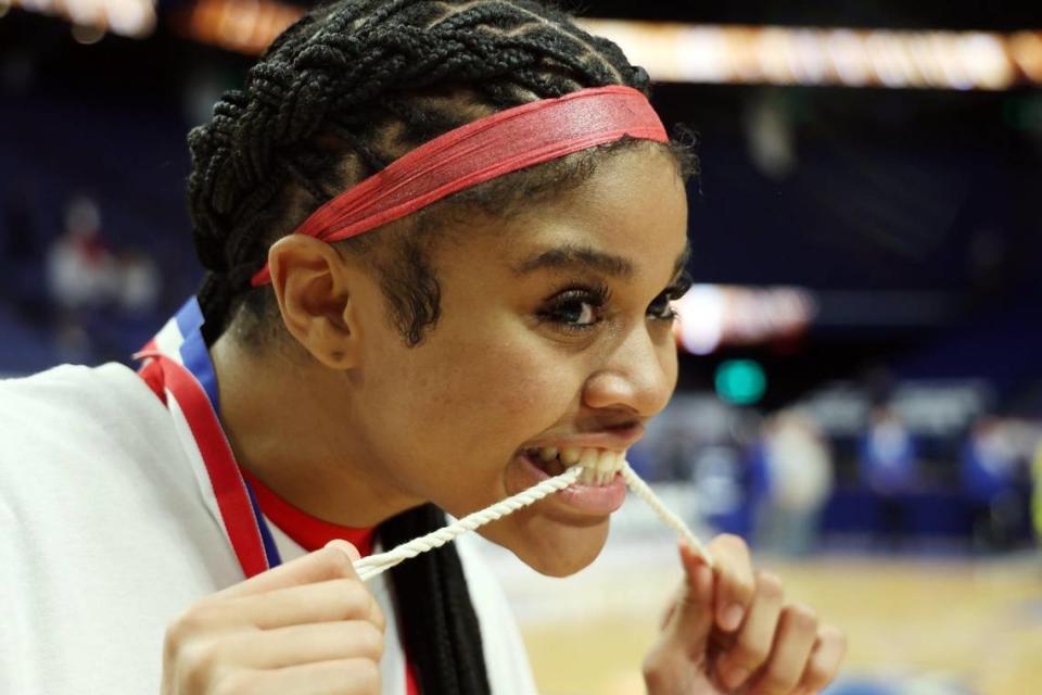 Sacred Heart’s ZaKiyah Johnson (11) celebrates with a piece of game net after the championship game of the Mingua Beef Jerky Girls’ Sweet 16 state basketball tournament at Rupp Arena on March 16.