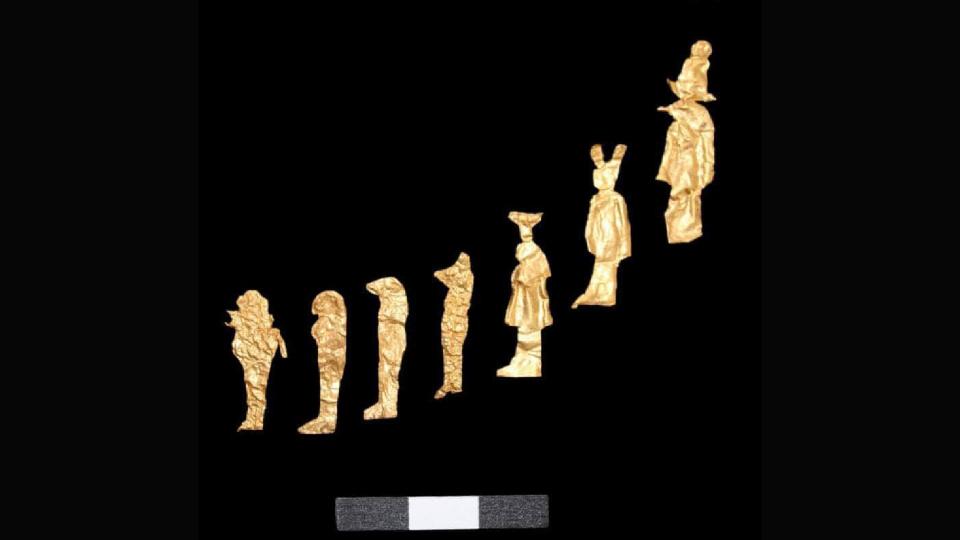 Gold figurines are laid out in a diagonal line