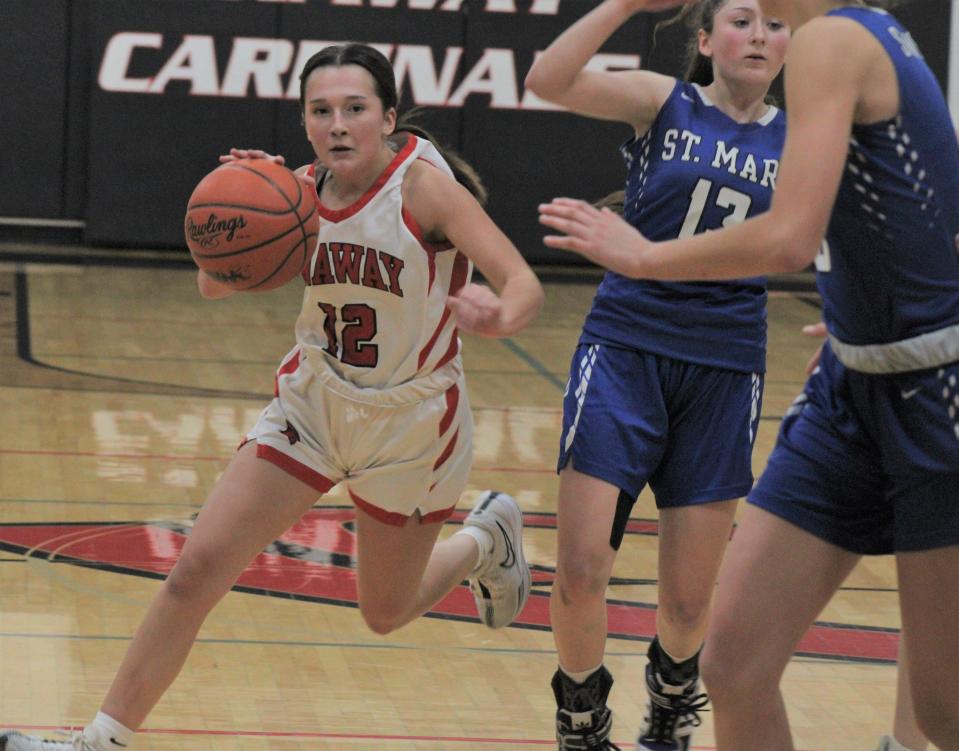 Onaway sophomore guard Marley Szymoniak (12) drives past a pair of Gaylord St. Mary defenders during a girls basketball home game on Wednesday, Feb. 14.