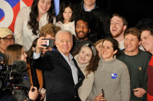 Former vice president Joe Biden takes selfies with supporters after speaking at a rally in Manchester, New Hampshire