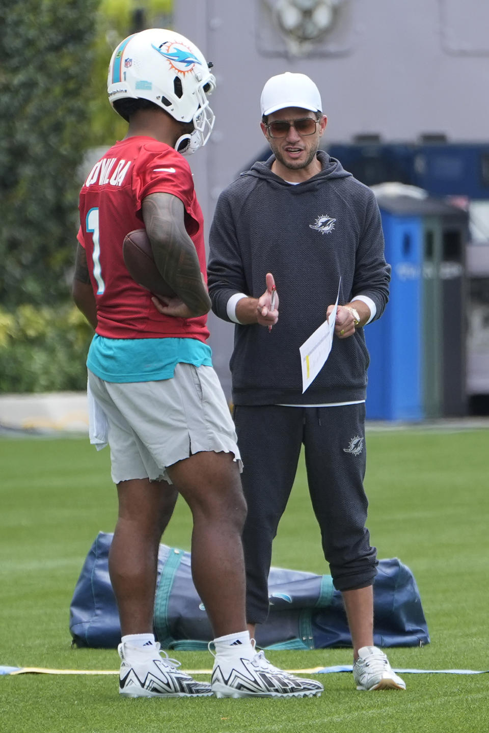 Miami Dolphins head coach Mike McDaniel talks to quarterback Tua Tagovailoa (1) during an NFL football practice, Tuesday, May 28, 2024, in Miami Gardens, Fla. (AP Photo/Marta Lavandier)
