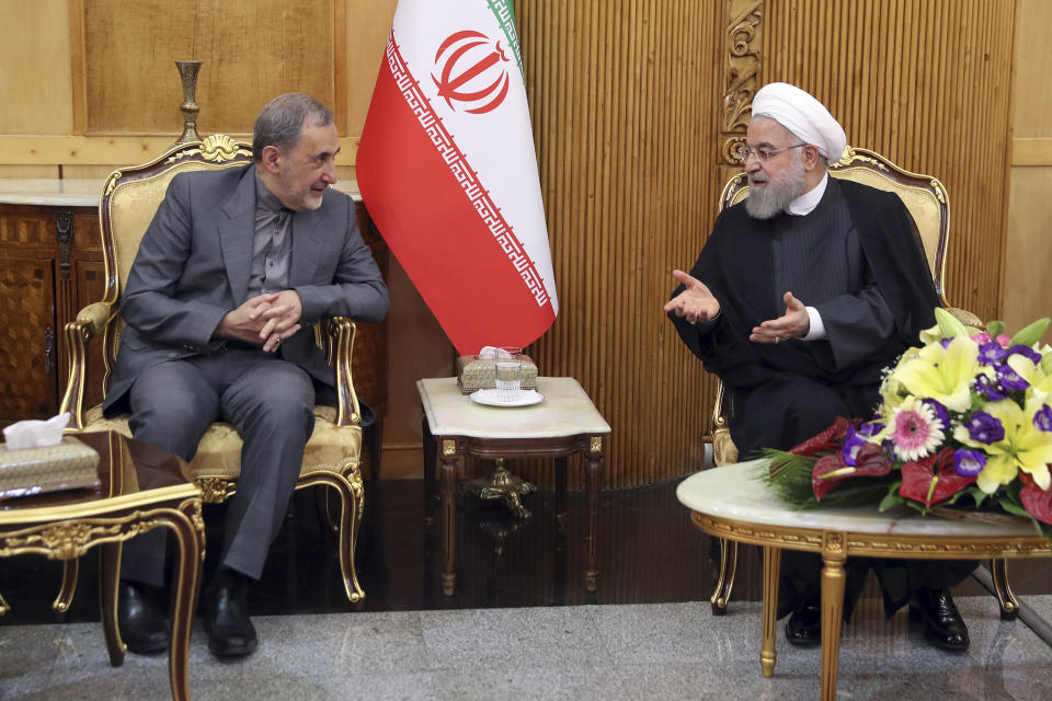 In this photo released by the official website of the office of the Iranian Presidency, President Hassan Rouhani, right, speaks with advisor to the supreme leader, Ali Akbar Velayati, at Mehrabad airport pavilion upon arriving in Tehran from New York, where he attended the United Nations General Assembly, Iran, Friday, Sept. 27, 2019. Rouhani said U.S. sanctions on his country are "more unstable than ever." (Iranian Presidency Office via AP)