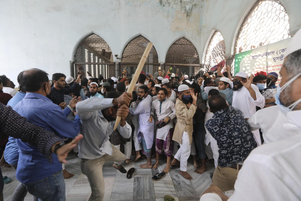 Two factions of protestors clash after Friday prayers at Baitul Mokarram mosque in Dhaka, Bangladesh, Friday, March 26, 2021. Witnesses said violent clashes broke out after one faction of protesters began waving their shoes as a sign of disrespect to Indian Prime Minister Narendra Modi, and another group tried to stop them. Local media said the protesters who tried to stop the shoe-waving are aligned with the ruling Awami League party. The party criticized the other protest faction for attempting to create chaos in the country during Modi’s visit. (AP Photo/Mahmud Hossain Opu)