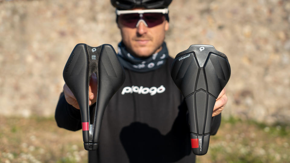  A rider holds the new Prologo Dimension AGX and Scratch M5 AGX saddles 