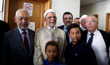 Rached Ghannouchi, leader of the moderate Islamist party Ennahda in Tunisia and party vice-president Abdel Fattah Morou, pose for photos after Morou submitted his candidacy for the presidential election in Tunis