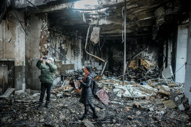 Periodistas filman la fábrica de confección destruida en la ciudad portuaria de Odessa después de un ataque de drones durante la noche. 