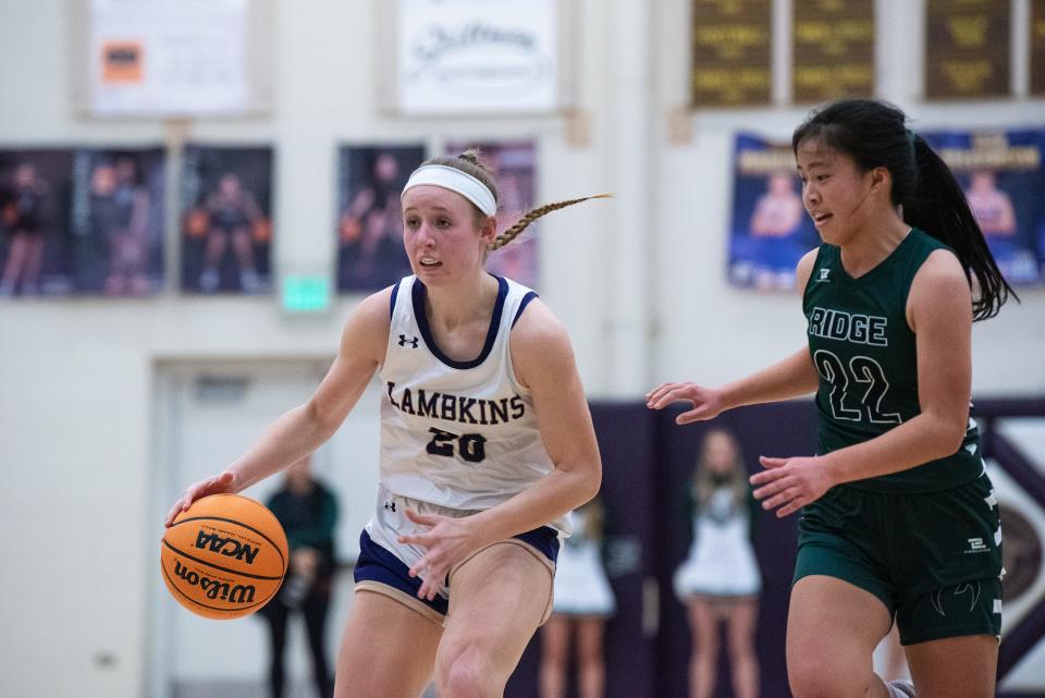 Fort Collins girls basketball's Paige Fry (20) is defended by SaberCat Natalie Lin (22) during a city rivalry boys-girls doubleheader against Fossil Ridge on Tuesday, January 30, 2024, at Fort Collins High School in Fort Collins, Colo. The Lambkins won 65-50.