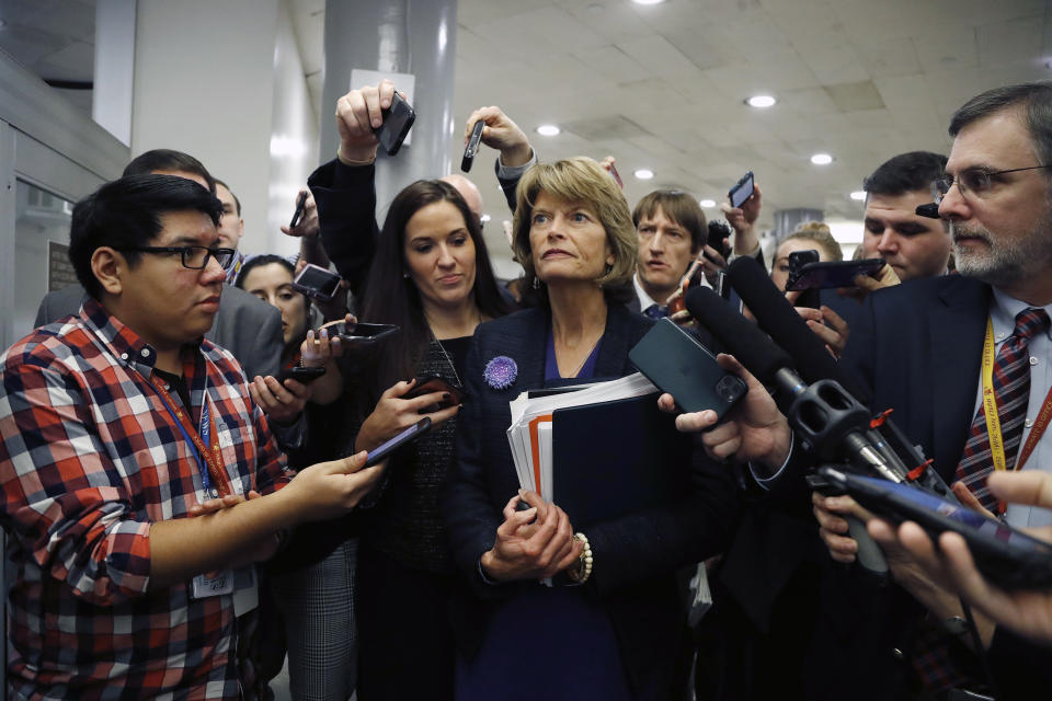 Sen. Lisa Murkowski, surrounded by reporters, leaves a session of the impeachment trial of President Trump. (Julio Cortez/AP)