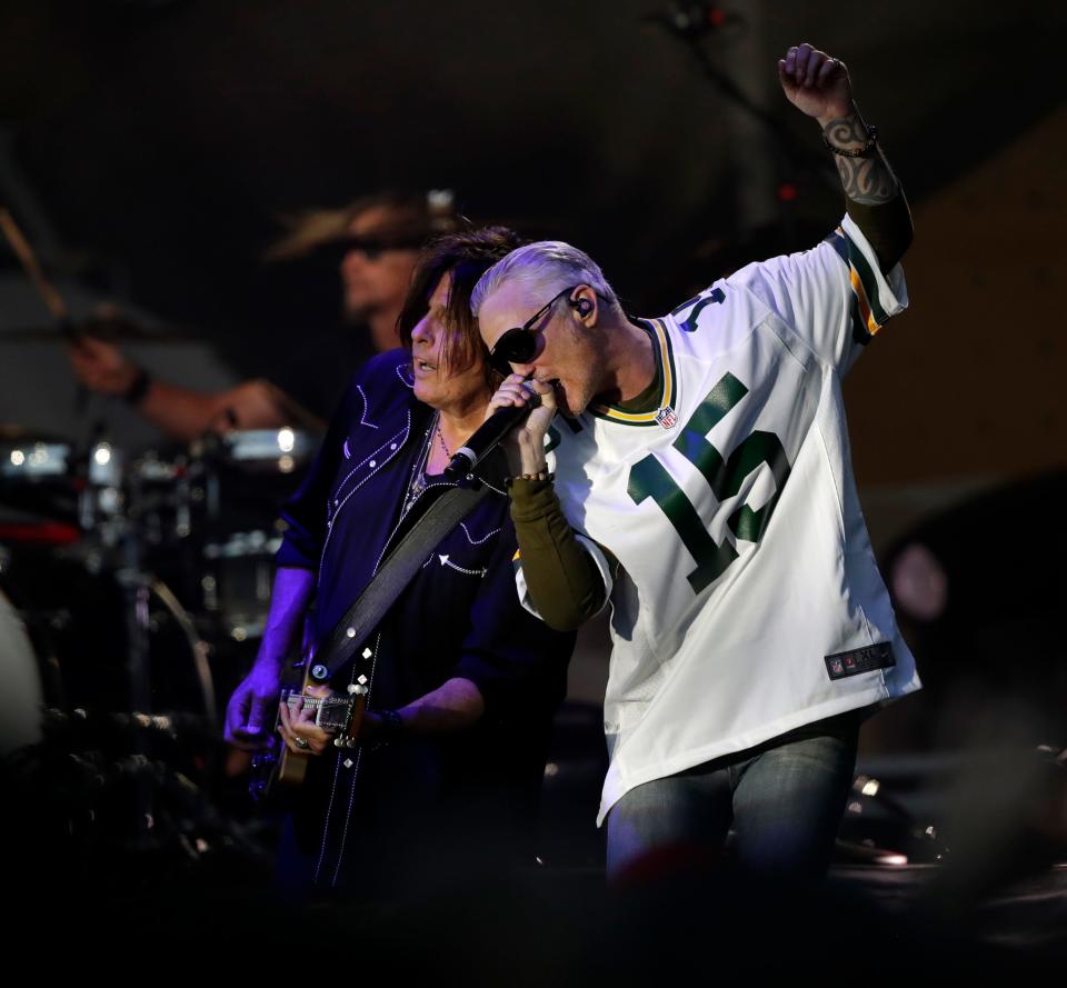 Dean DeLeo, left, and Jeff Gutt of Stone Temple Pilots lean into during the Green Bay Packers' Kickoff Weekend concert on Saturday night  outside Lambeau Field.