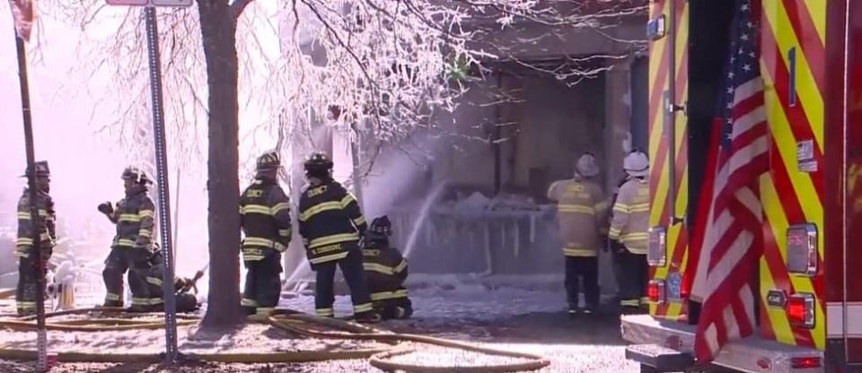 Quincy firefighters working in frigid weather put out a fire at Quincy Collision & Frame Center on Liberty Street on Saturday, Feb. 4, 2023.