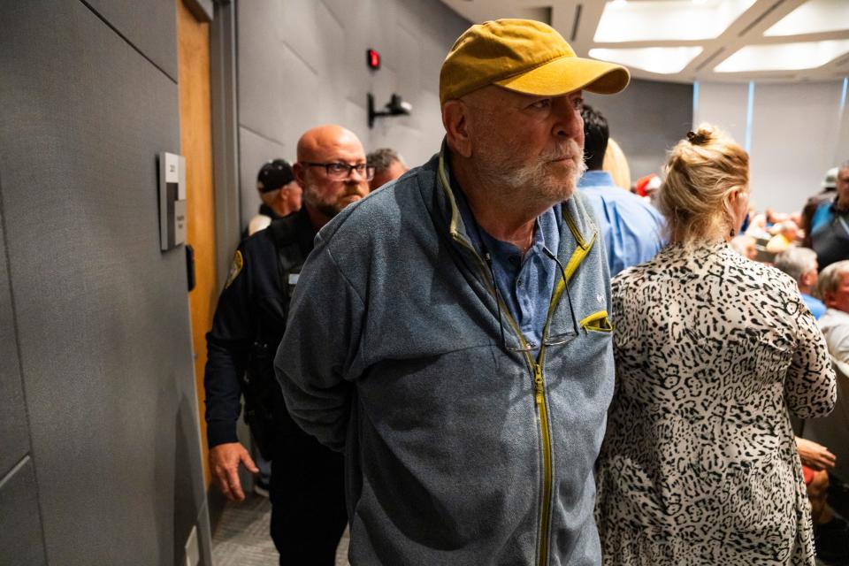 Scott Kempe is escorted out of the meeting chamber by police officers after being arrested during a city council meeting at Cape Coral City Hall in Cape Coral on Wednesday, Dec. 13, 2023. After being escorted out of a previous meeting, the council was slated to discuss whether he could return.