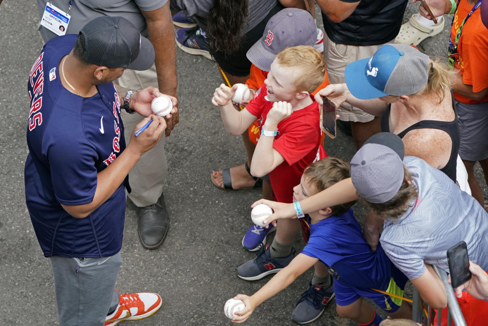 Boston Red Sox's Rafael Devers, left, gives autographs as his team arrives at the Little League World Series tournament in South Williamsport, Pa., Sunday, Aug. 21, 2022. (AP Photo/Tom E. Puskar)
