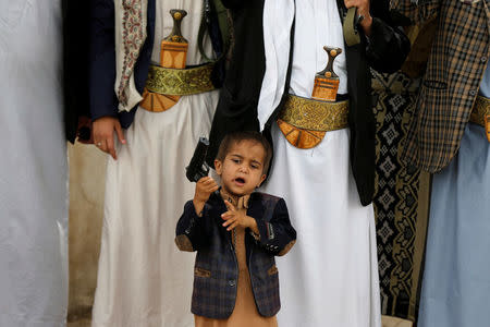 A boy holds his father's pistol as he attends with tribesmen loyal to the Houthi movement a gathering to show support to the movement in Sanaa, Yemen, May 26, 2016. REUTERS/Khaled Abdullah