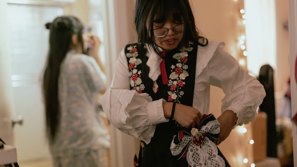 Kandace assembles her dress while Nghi puts her make-up on as they prepare for a Lolita meet-up in San Francisco, California, on Dec 3, 2022. The skirt's fullness, achieved through the use of a petticoat, is a key characteristic of Lolita fashion. - Shelby Knowles