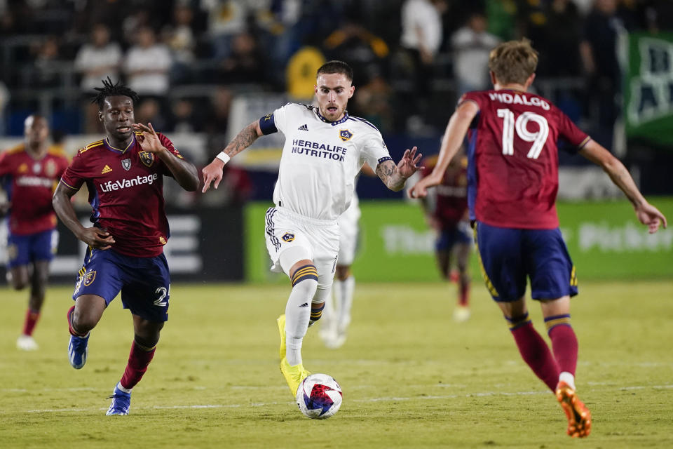 LA Galaxy midfielder Tyler Boyd, center, dribbles the ball as Real Salt Lake midfielder Emeka Eneli, left, and midfielder Bode Hidalgo close in during the second half of an MLS soccer match Saturday, Oct. 14, 2023, in Carson, Calif. (AP Photo/Ryan Sun)