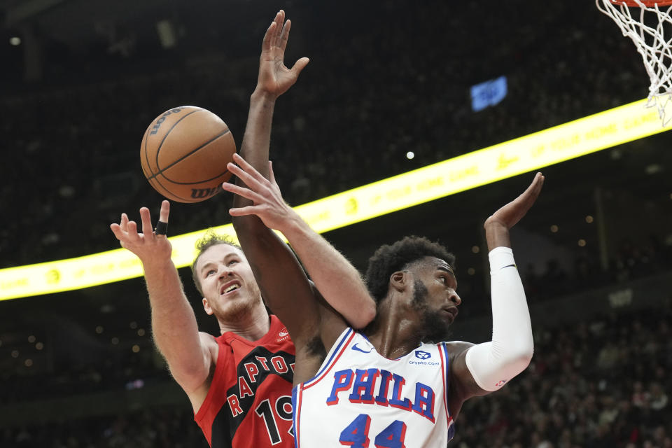 Toronto Raptors' Jakob Poeltl, left, and Philadelphia 76ers' Paul Reed reach for the ball during the first half of an NBA basketball game Saturday, Oct. 28, 2023, in Toronto. (Chris Young/The Canadian Press via AP)