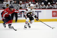 Chicago Blackhawks right wing Patrick Kane (88) skates with the puck against Washington Capitals left wing Carl Hagelin (62) during the second period of an NHL hockey game Thursday, Dec. 2, 2021, in Washington. (AP Photo/Nick Wass)